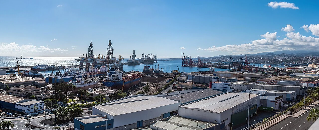 Puerto de Las Palmas de Gran Canaria, con instalaciones comerciales, barcos y la ciudad al fondo